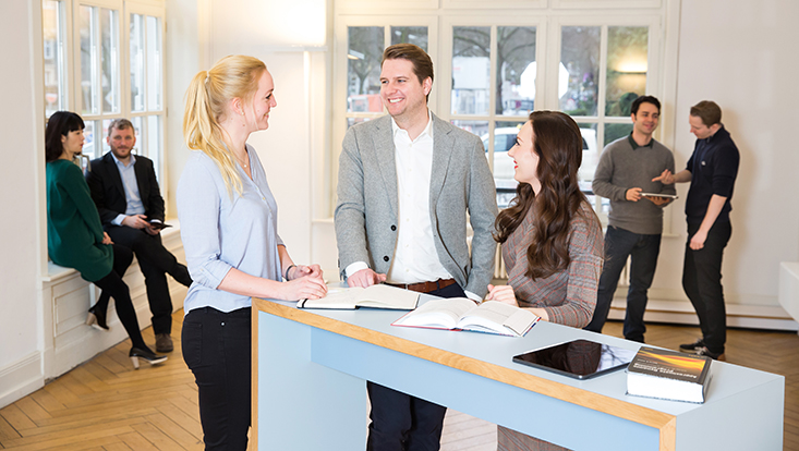 Blick in einen Raum im Haus der Betriebswirtschaft, in dem viele Wissenschaftler im Gespräch sind
