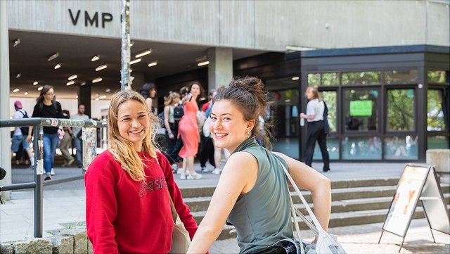 Studierende, die vor einem Uni Gebäude stehen