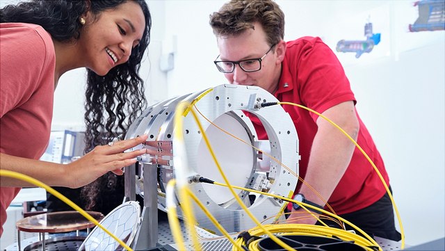 Personen stehen an einer Maschine