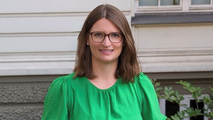 Dekanin vor historischem Gebäude