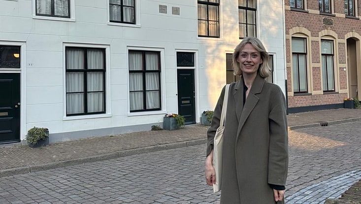 Junge Frau vor alten Häusern