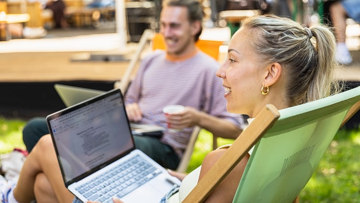 Frau in Liegestuhl mit Laptop