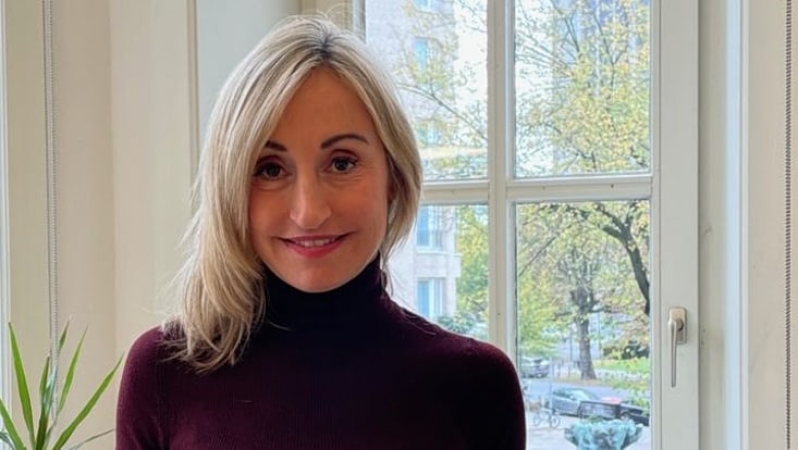 Lächelnde Frau vor Fenster